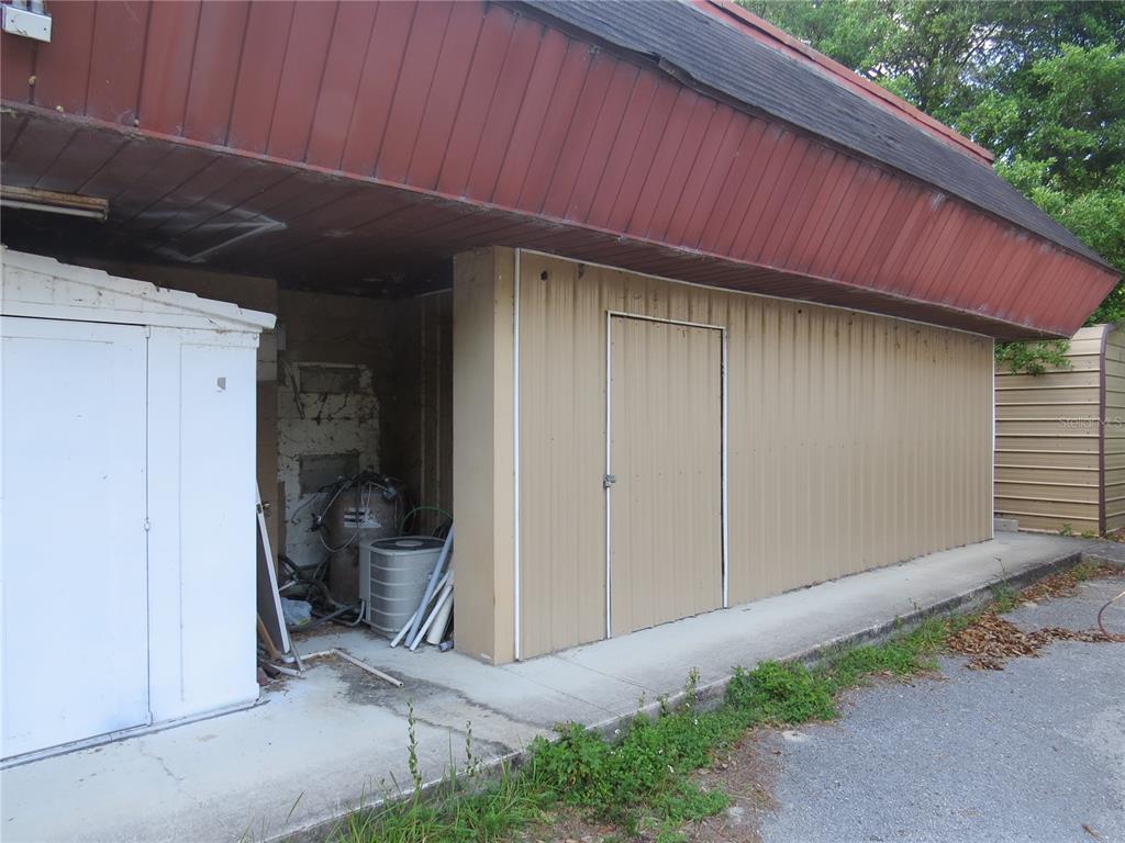 An exterior view of a building with a tan metal wall, a door, and equipment — 28380 FORBES STREET, NOBLETON, FL