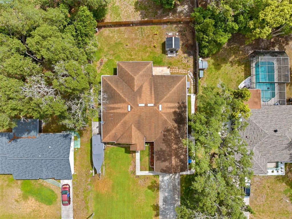 An aerial view shows a house with a brown roof, a driveway, and a boat — 8053 TIMBERLAKE AVENUE, SPRING HILL, FL
