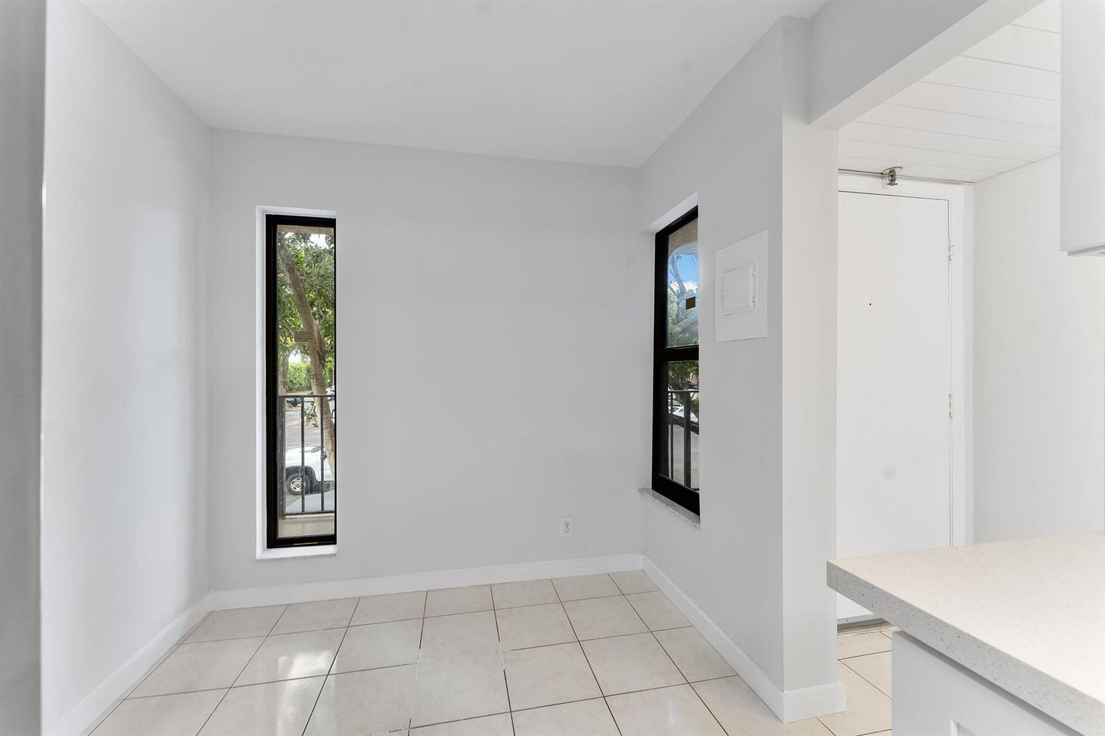 A bright, tiled dining area features two tall windows with black frames and white walls — 20 Royal Palm Way # 2060, Boca Raton FL 33432, BOCA RATON, FL
