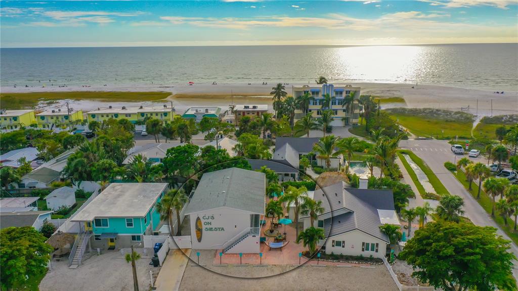 An aerial view shows a multi-unit residential building near a sandy beach and ocean — 104 AVENIDA VENECCIA UNIT 171, SARASOTA, FL