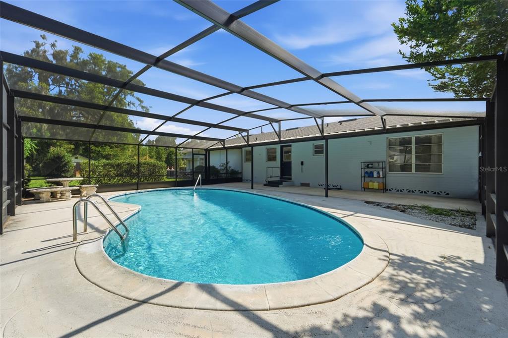 A screened-in patio features a swimming pool, concrete decking, and a light blue exterior wall — 790 S BOUNDARY AVENUE, DELAND, FL