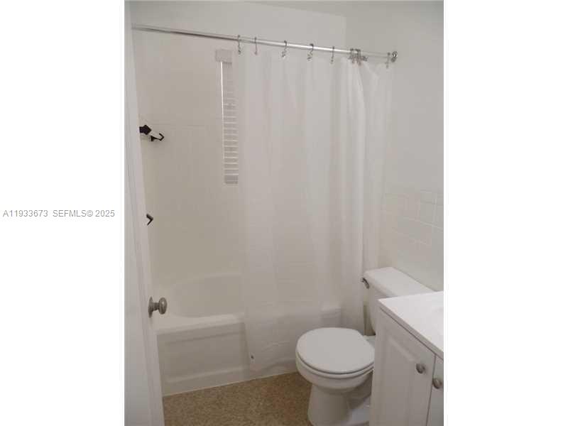 A bathroom features a white vanity, a toilet, and a shower-tub combination with a curtain — 6950 Byron Ave # 4, Miami Beach FL 33141, MIAMI BEACH, FL