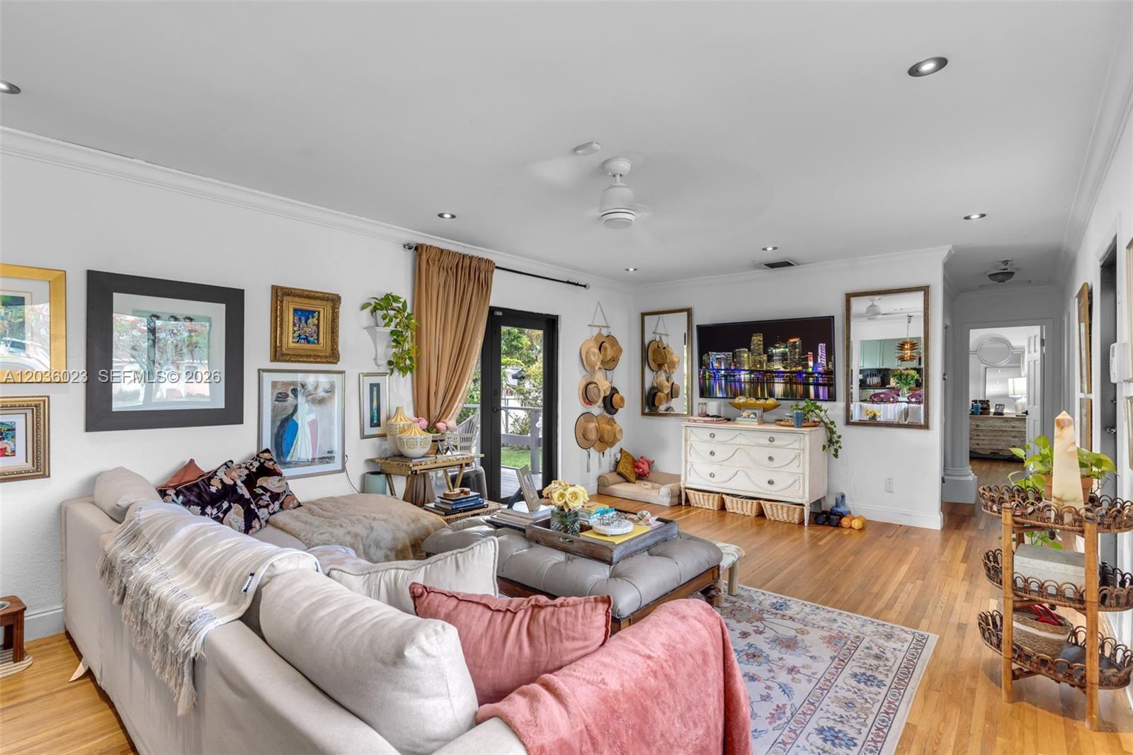 A living room features a sectional sofa, a gray ottoman, and a wall-mounted television — 8281 SW 27th Ln, Miami FL 33155, MIAMI, FL