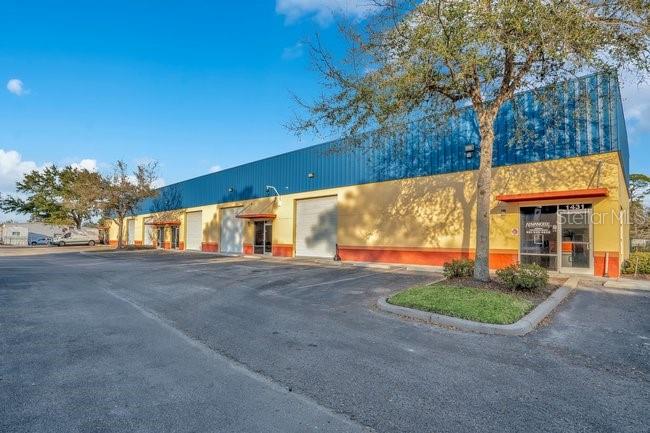 A commercial warehouse building with a blue metal roof and yellow exterior walls — 201 REECE WAY UNIT 1425, CASSELBERRY, FL