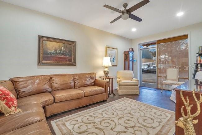 A living room features a large brown leather sectional, a patterned area rug, and a ceiling fan — 201 REECE WAY UNIT 1425, CASSELBERRY, FL