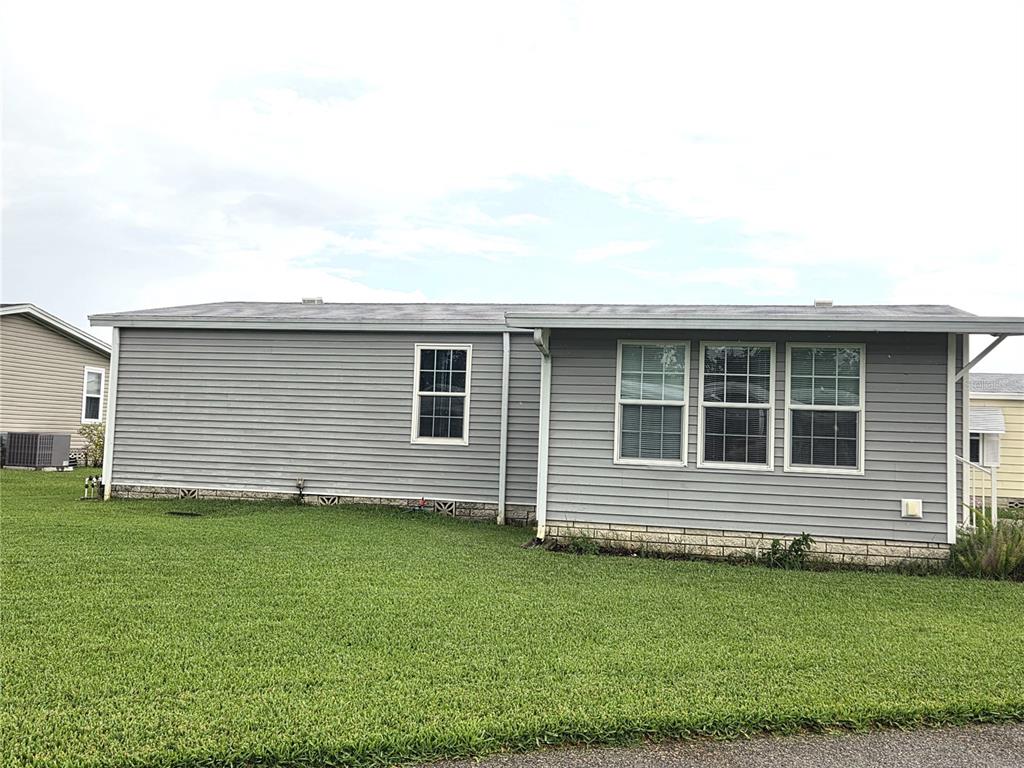 A gray single-story manufactured home with vinyl siding sits on a grassy lawn — 332 VICTORIA DRIVE, HAINES CITY, FL