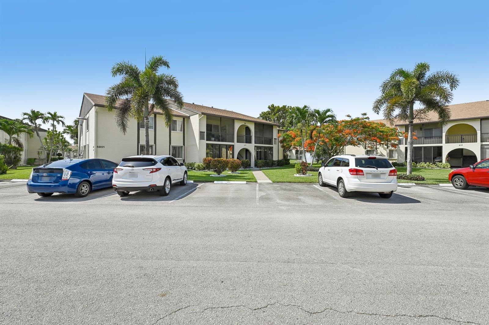 A two-story apartment building with a parking lot and palm trees in front — 5901 Whispering Pine Way # 2, FL 33463, FL