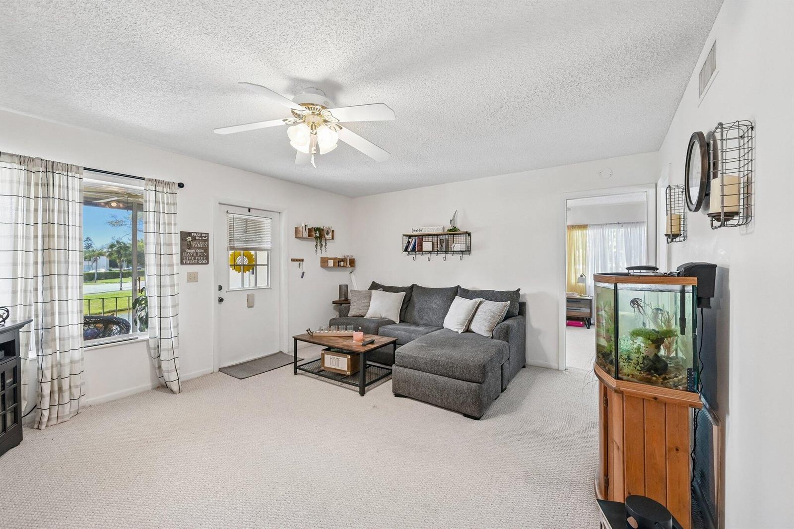 A living room features a gray sectional sofa, a coffee table, and a fish tank — 5901 Whispering Pine Way # 2, FL 33463, FL