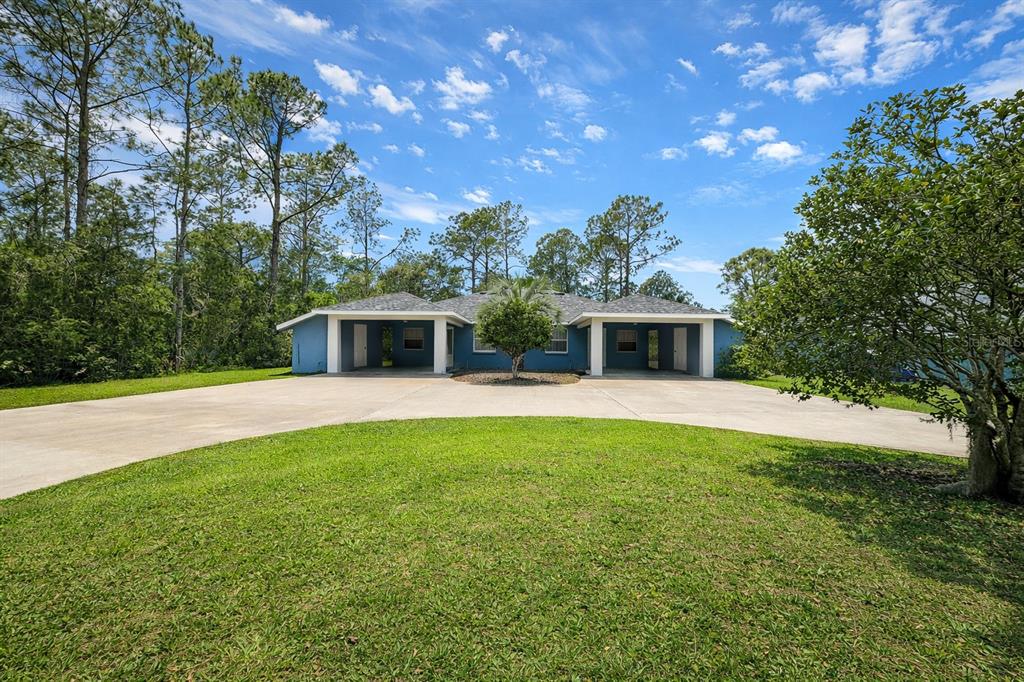 A blue single-story house with two attached garages and a large concrete driveway — 9 WHEELER PLACE UNIT A, B, PALM COAST, FL