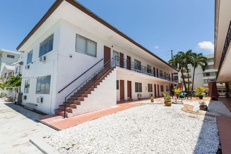 An exterior view of a two-story apartment building with a courtyard and waterfront access — 8220 Byron Ave, Miami Beach FL 33141, MIAMI BEACH, FL