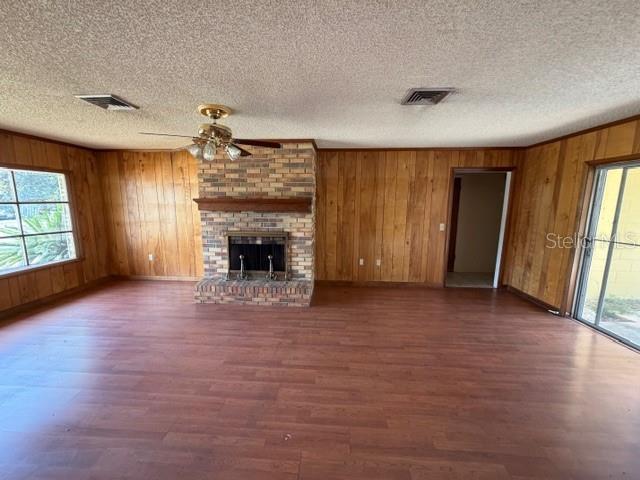 A living room features wood-paneled walls, a brick fireplace, and wood-look flooring — 1105 GAUSE AVENUE, BARTOW, FL