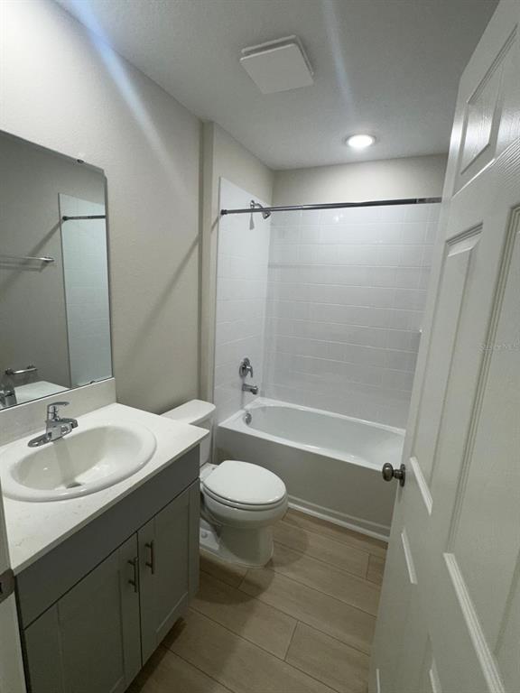 A bathroom features a gray vanity, a white toilet, and a tub-shower combo — 1049 FORESHORE LANE, HAINES CITY, FL