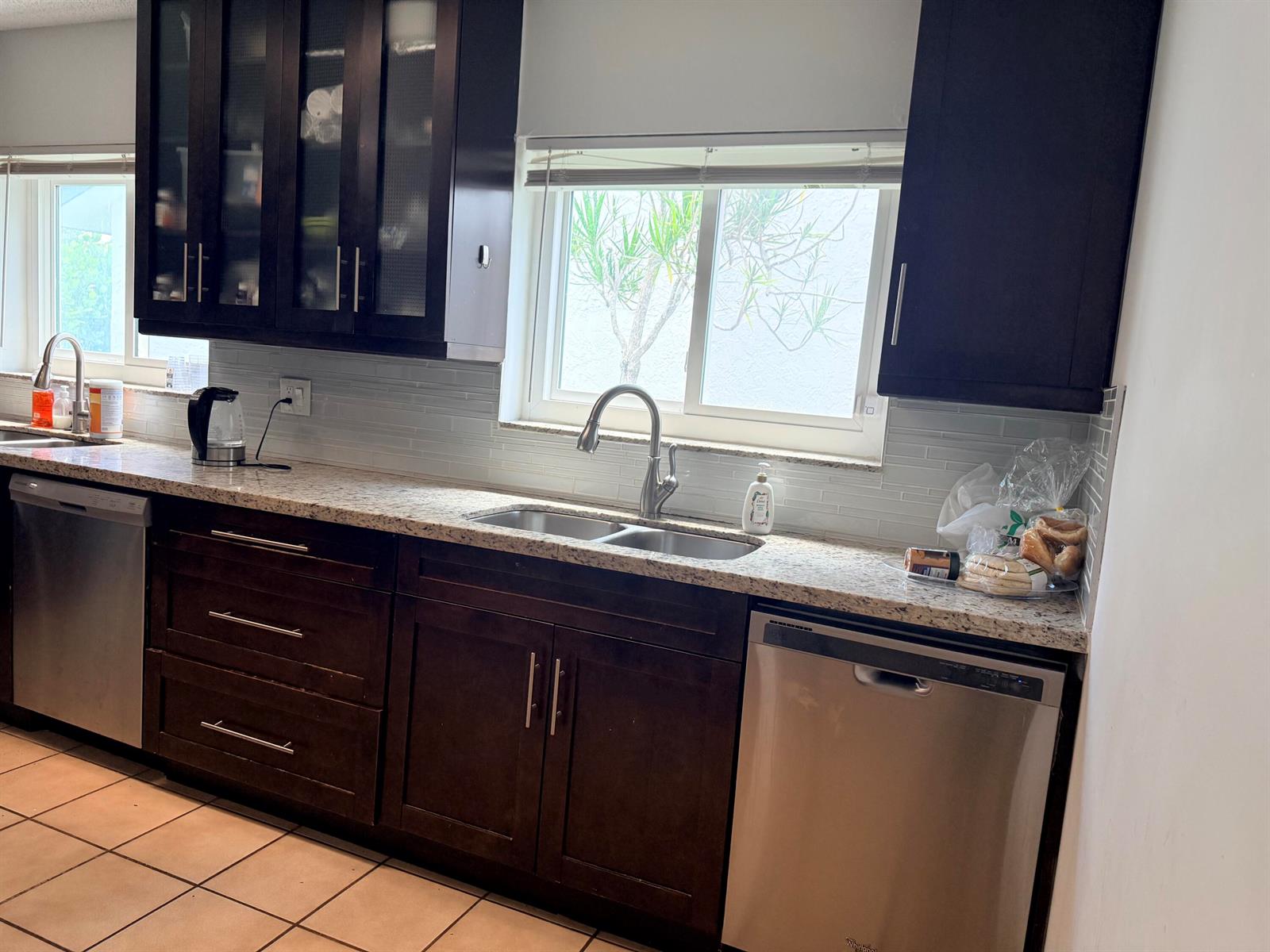 A kitchen features dark wood cabinets, granite countertops, stainless steel appliances, and a tiled floor — 7797 San Marcos Place, Boca Raton FL 33433, BOCA RATON, FL