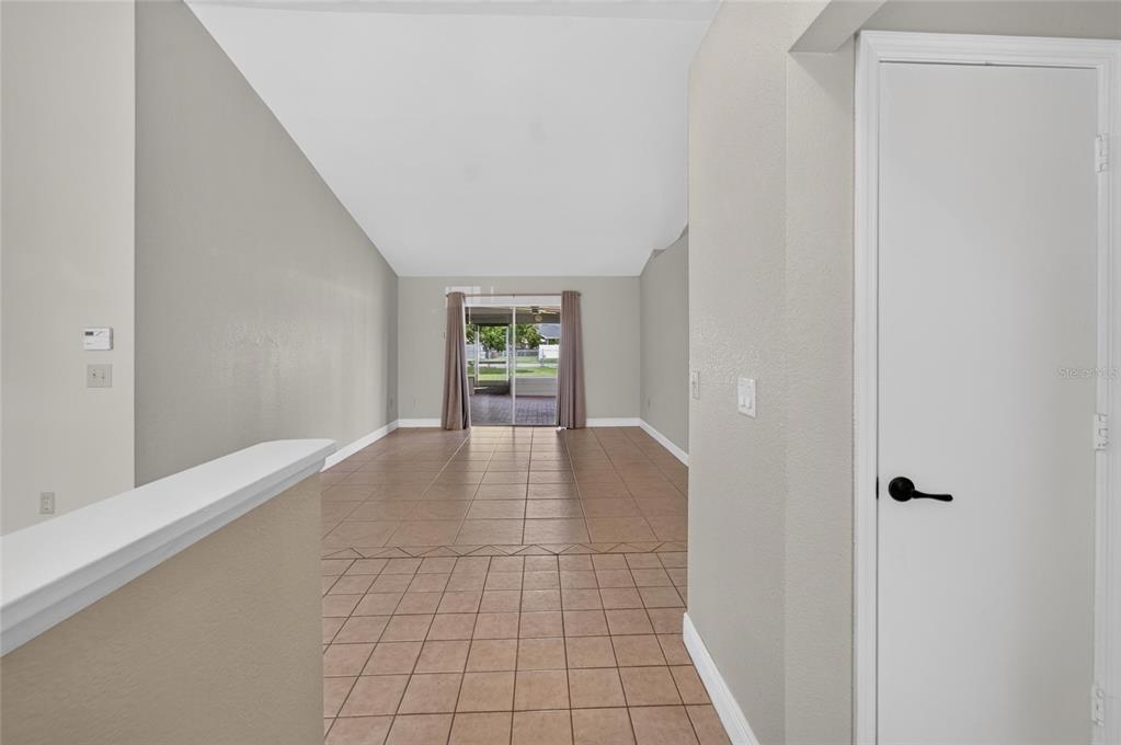 A tiled living area features a vaulted ceiling and sliding glass doors leading to a patio — 5309 ST LUCIA DRIVE, LAKELAND, FL