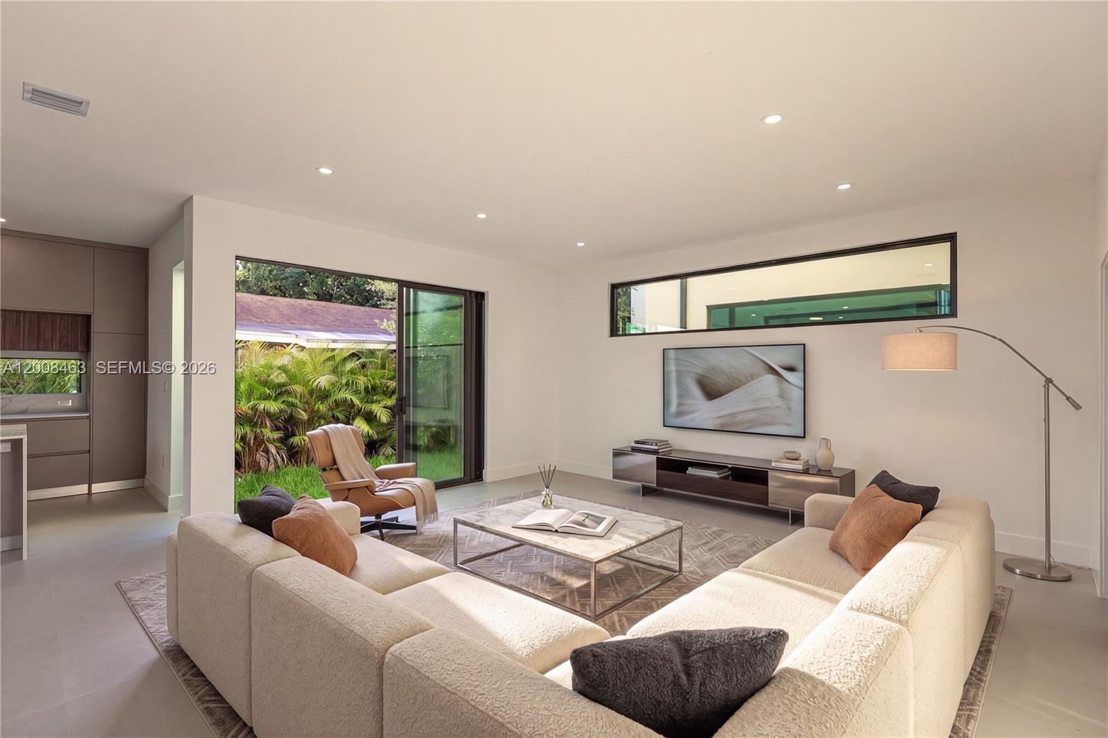 A modern living room features a large sectional sofa, a marble coffee table, and sliding doors — 5800 NW 5th Ave #5800, Miami FL 33127, MIAMI, FL