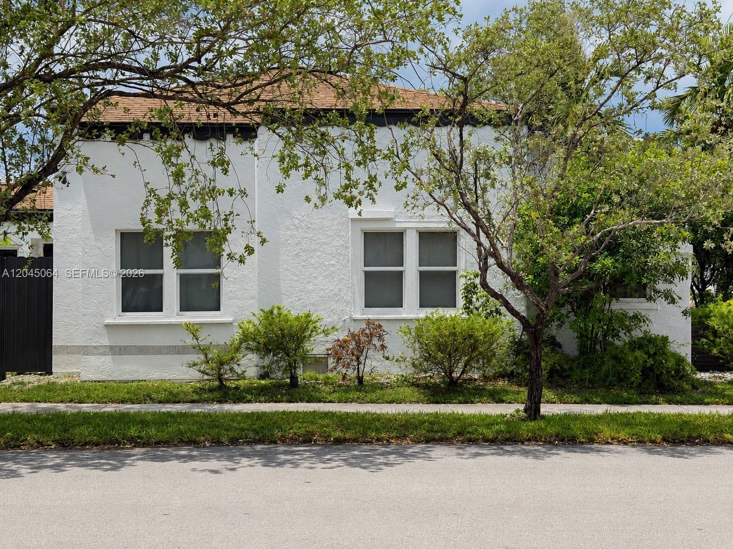 A white stucco house with two sets of windows sits behind a small front yard — 1700 Dewey St, Hollywood FL 33020, HOLLYWOOD, FL
