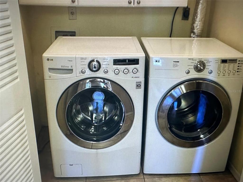 A laundry room contains a white LG front-loading washing machine and a matching dryer — 1071 S HIAWASSEE ROAD UNIT 1213, ORLANDO, FL