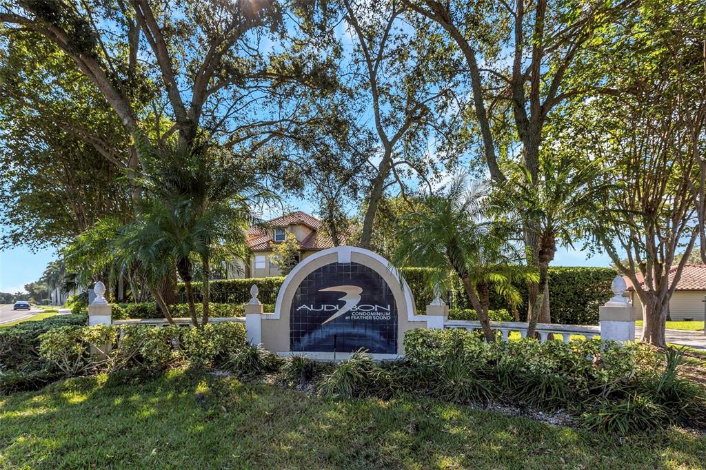 A sign for Audubon Condominium at Feather Sound stands in front of trees and buildings — 2400 FEATHER SOUND DRIVE UNIT 412, CLEARWATER, FL