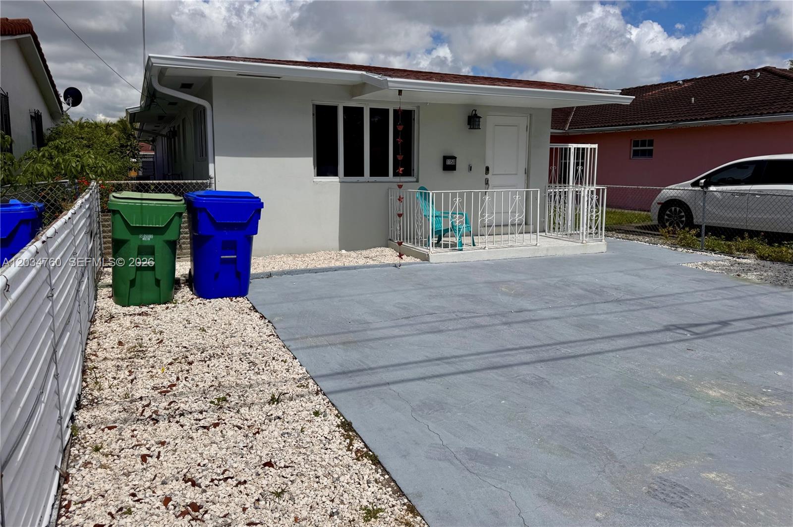 A single-story house with a white exterior, a small front porch, and a paved driveway — 1158 NW 34th Ave # 1, Miami FL 33125, MIAMI, FL