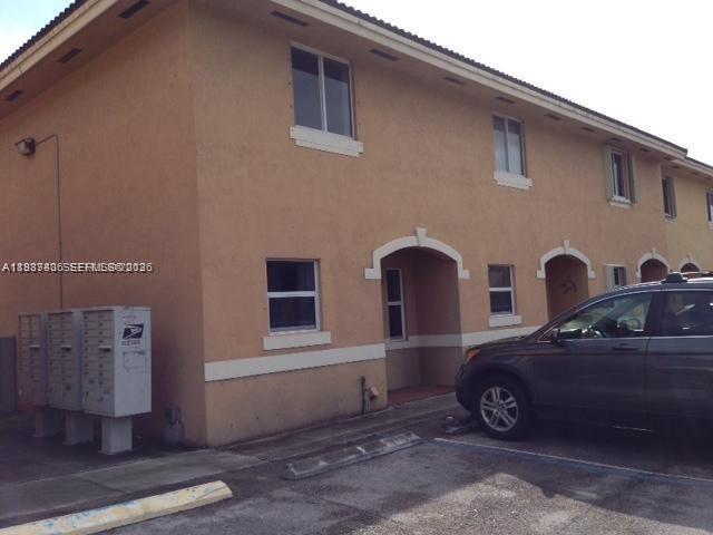 A two-story tan stucco apartment building with a row of mailboxes and a parked car — 7905 NW 8 ST # 8A, Miami FL 33126, MIAMI, FL