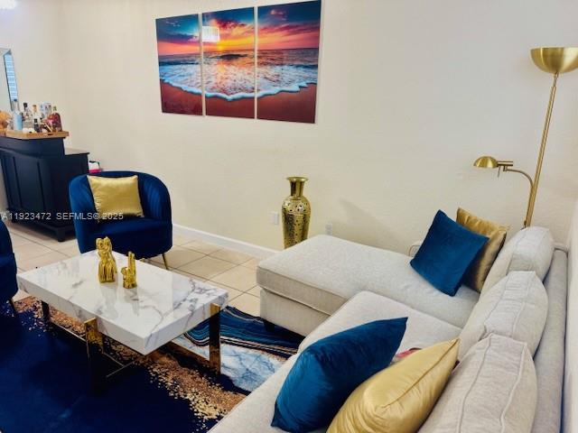 A living room features a white marble coffee table, blue armchair, and a sectional sofa — 2811 SE 17th Ave # 110, Homestead FL 33035, HOMESTEAD, FL