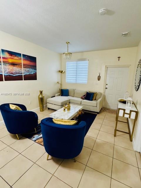 A living room features two blue armchairs, a sectional sofa, and a marble coffee table — 2811 SE 17th Ave # 110, Homestead FL 33035, HOMESTEAD, FL