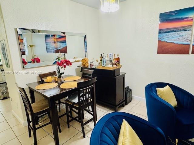 A dining area features a dark wood table with four chairs and a bar cabinet — 2811 SE 17th Ave # 110, Homestead FL 33035, HOMESTEAD, FL