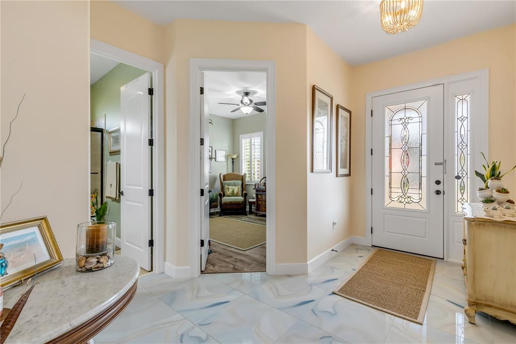 An entryway features light-colored marble-look tile flooring, a white front door, and two doorways — 3364 TORRE BOULEVARD, NEW SMYRNA BEACH, FL