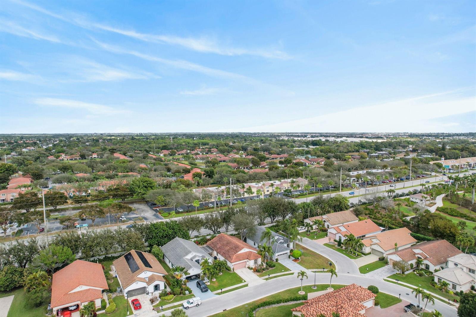 An aerial view shows a suburban neighborhood with houses, streets, and a nearby commercial area — 10056 Lexington Circle N, Boynton Beach FL 33436, BOYNTON BEACH, FL