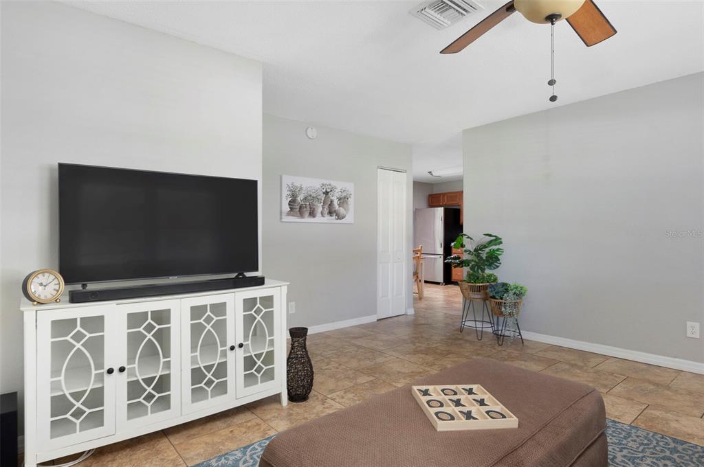 A living room features tile flooring, a white media console, and a ceiling fan — 1744 26TH AVENUE N, ST PETERSBURG, FL