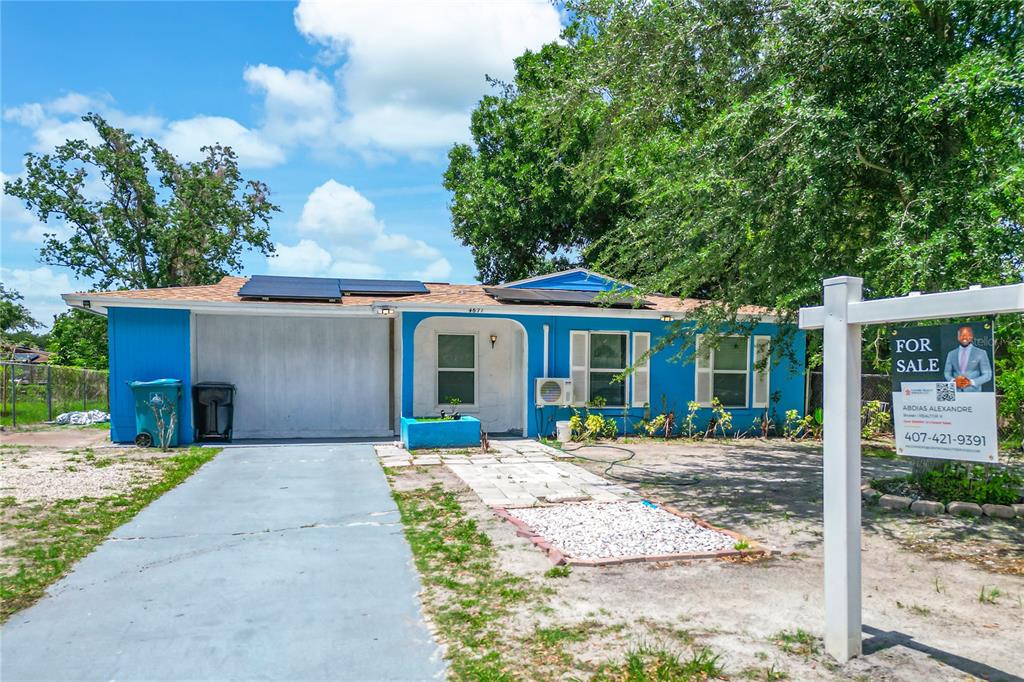 A blue single-story house with a driveway and a for sale sign in the yard — 4671 VERGARA COURT, ORLANDO, FL