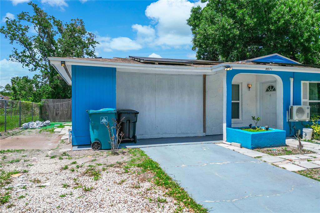 A single-story house with blue trim, a white garage door, and a gravel driveway — 4671 VERGARA COURT, ORLANDO, FL