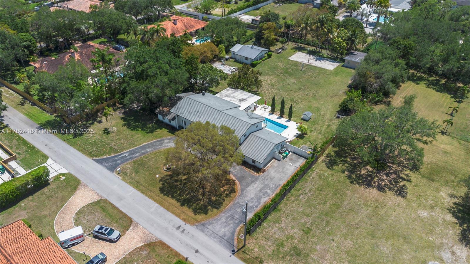 An aerial view shows a house with a pool, large yard, and paved driveway — 8350 SW 98 th St, Miami FL 33156, MIAMI, FL