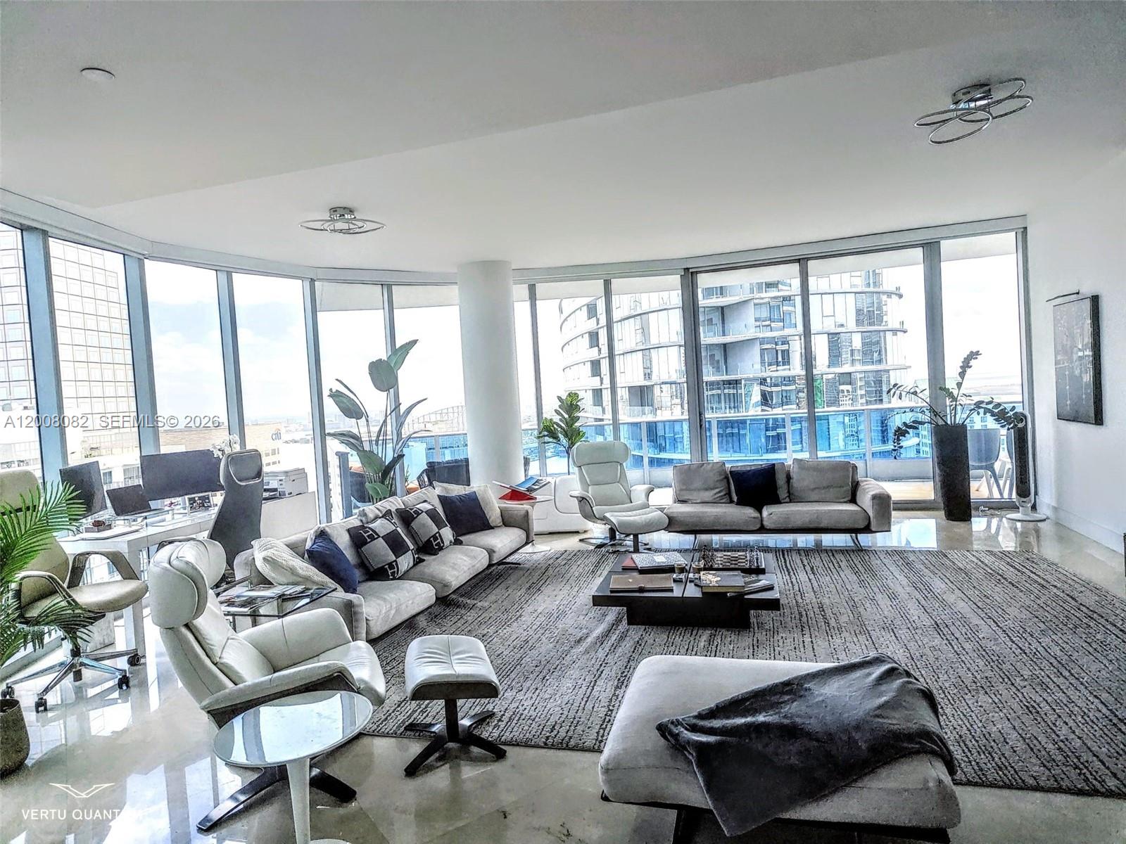 A spacious living room features floor-to-ceiling windows, modern furniture, and a large area rug — 200 Biscayne Boulevard Way # 5001, Miami FL 33131, MIAMI, FL