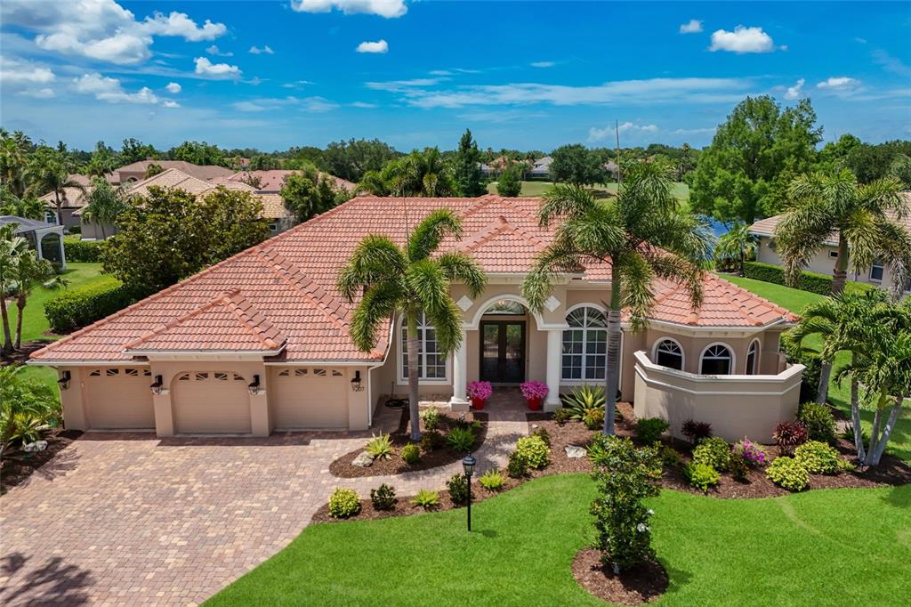 An aerial view of a single-story house with a tile roof and a paved driveway — 7207 ASHLAND GLEN, LAKEWOOD RANCH, FL