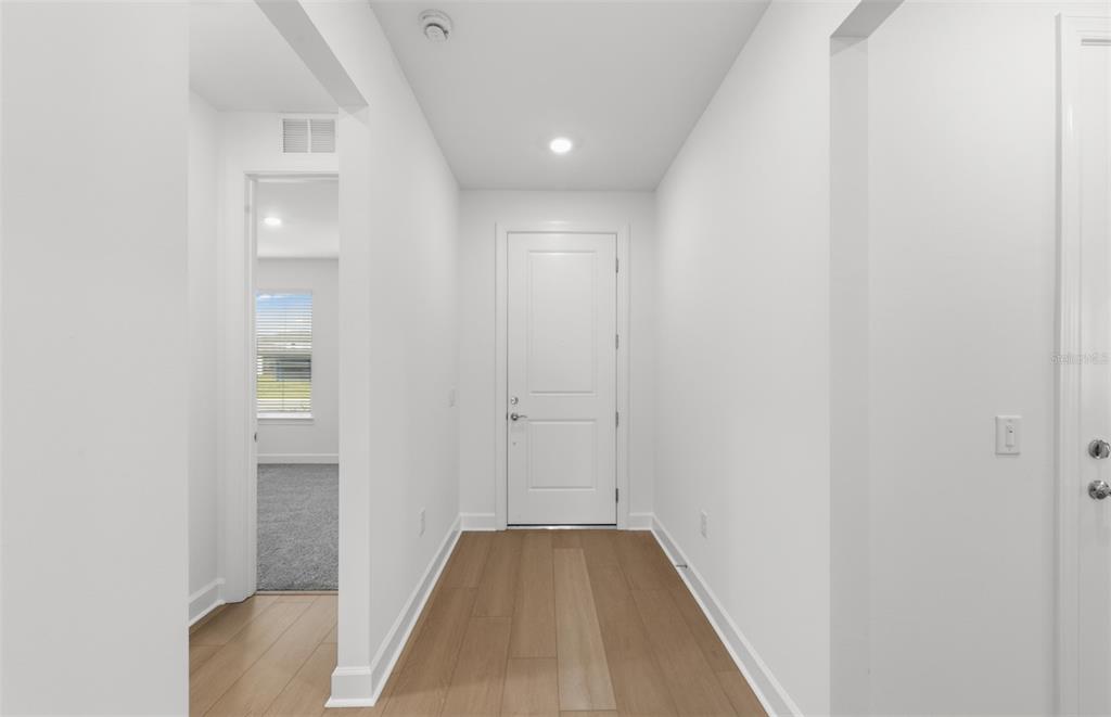 A bright entryway features light wood flooring, white walls, and a white front door — 16419 LILY ELAINE WAY, BRADENTON, FL