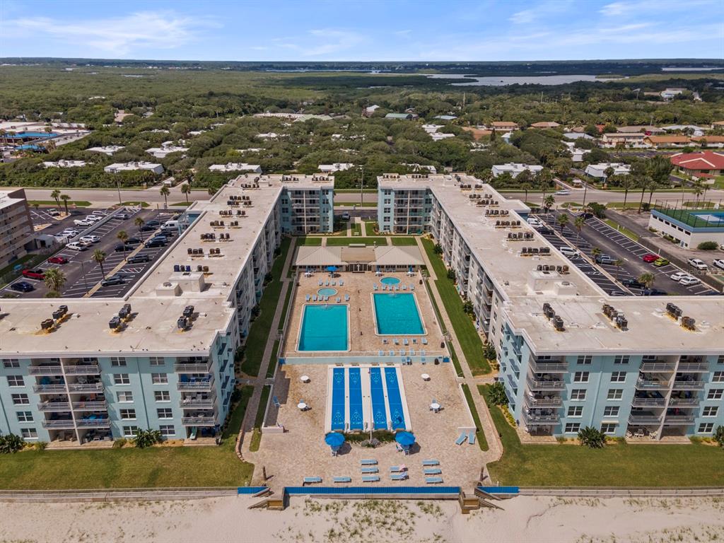An aerial view of a beachfront resort complex with multiple pools and a sandy beach — 4153 S ATLANTIC AVENUE UNIT 5110, NEW SMYRNA BEACH, FL