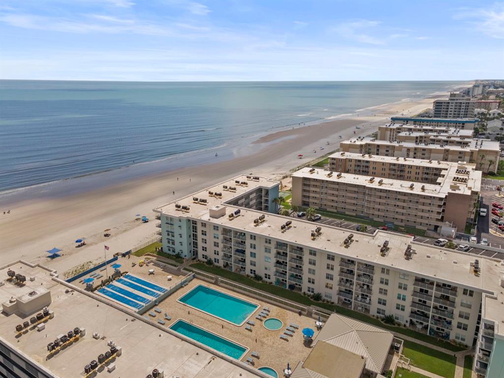 An aerial view shows two large apartment buildings with swimming pools located next to the beach — 4153 S ATLANTIC AVENUE UNIT 5110, NEW SMYRNA BEACH, FL