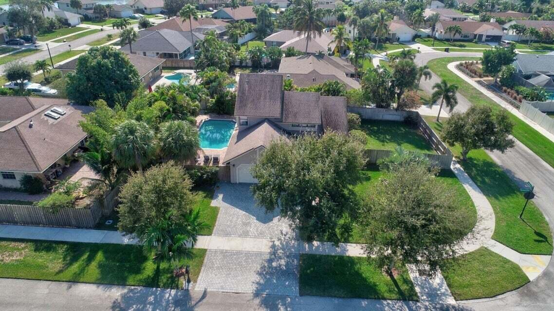 An aerial view of a two-story suburban house with a swimming pool and paved driveway — 4140 Woods End Road, Boca Raton FL 33487, BOCA RATON, FL
