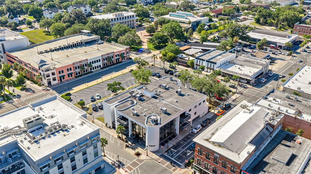 An aerial view shows a city block with a modern white building and parking structures — 35 SE 1ST AVENUE 2nd Floor, OCALA, FL