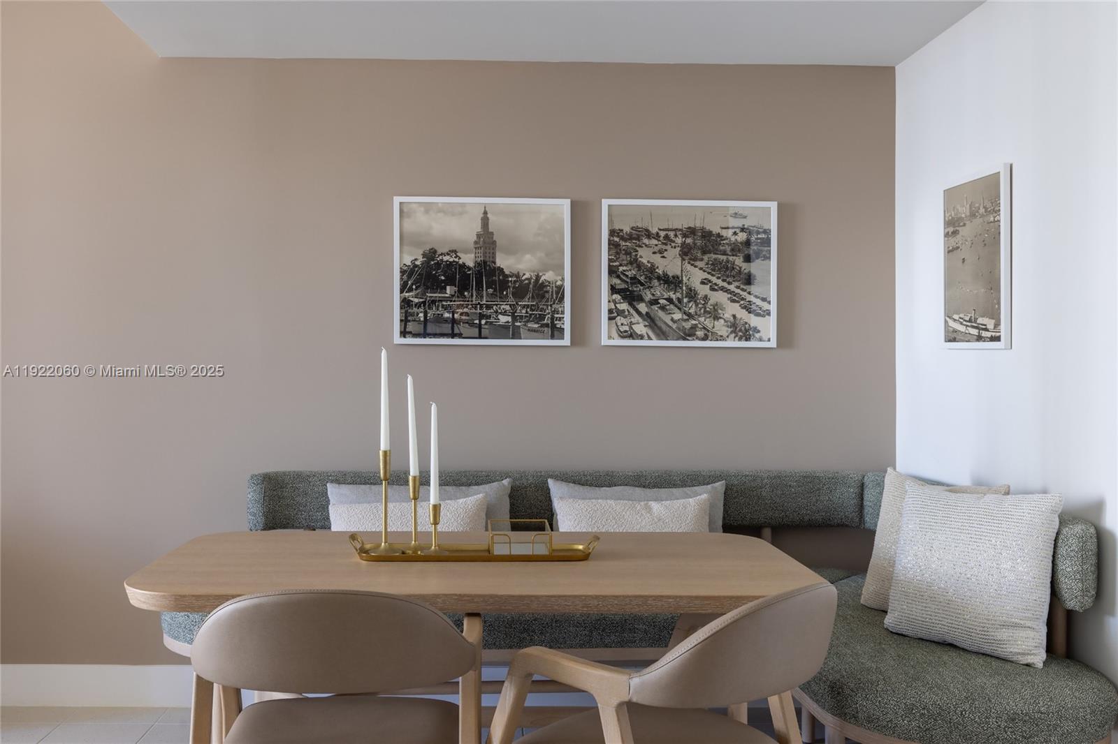 A dining area features a corner banquette, a wooden table, and three framed wall prints — 159 NE 6th St # 3209, Miami FL 33132, MIAMI, FL