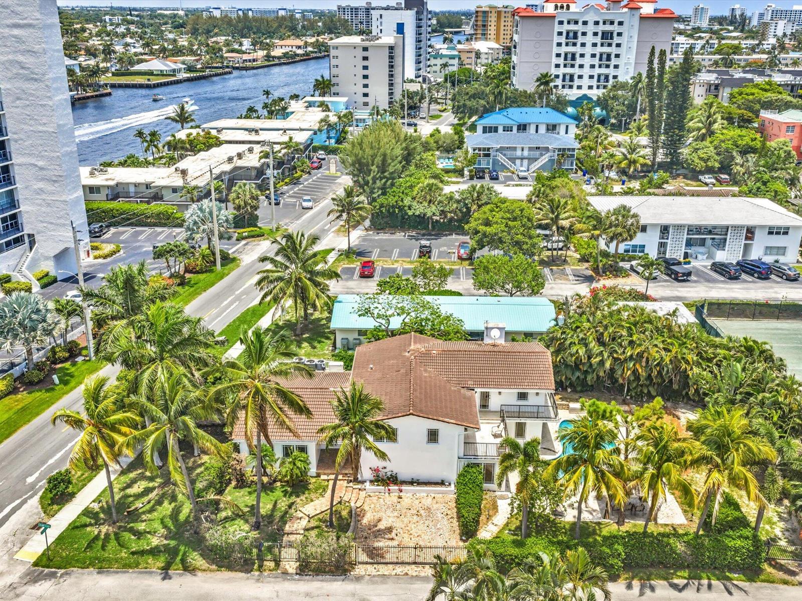 An aerial view of a white house with a brown roof, pool, and surrounding palm trees — 518 N Riverside Drive, Pompano Beach FL 33062, POMPANO BEACH, FL