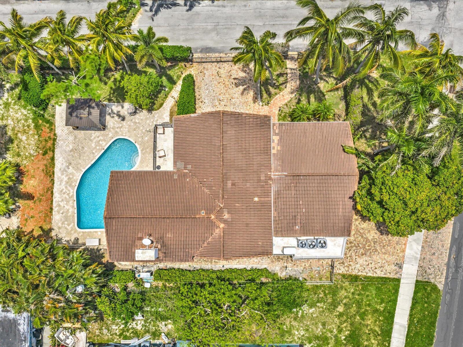 An aerial view shows a house with a tiled roof, a swimming pool, and palm trees — 518 N Riverside Drive, Pompano Beach FL 33062, POMPANO BEACH, FL