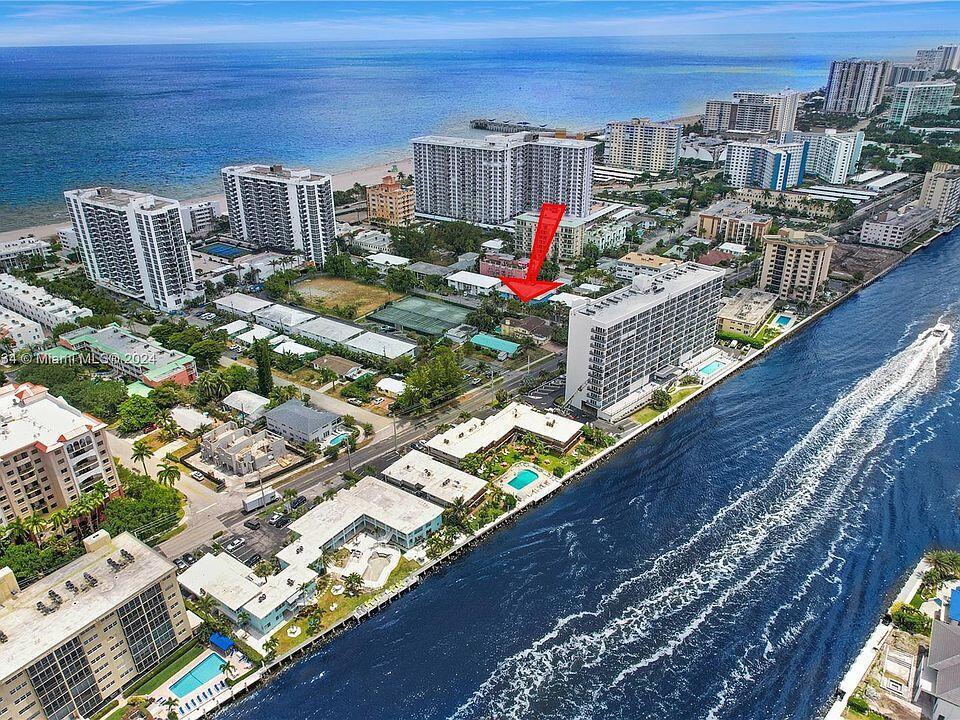 An aerial view shows a coastal neighborhood with high-rise buildings, a waterway, and a red arrow — 518 N Riverside Drive, Pompano Beach FL 33062, POMPANO BEACH, FL