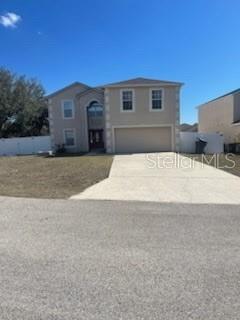 A two-story beige house with a two-car garage and a concrete driveway — 122 FLATFISH COURT, POINCIANA, FL