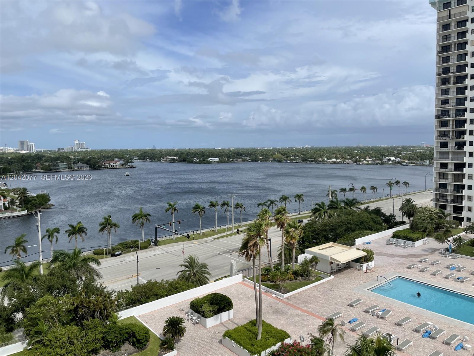 An elevated view shows a swimming pool, a coastal road, and a large body of water — 1201 S Ocean Dr # 1107S, Hollywood FL 33019, HOLLYWOOD, FL