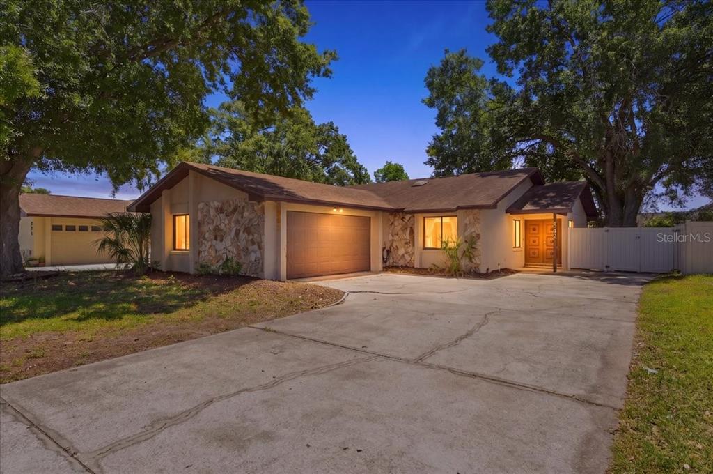 A single-story house with a stone facade, a two-car garage, and a concrete driveway — 842 ROCKINGHAM ROAD, LAKELAND, FL