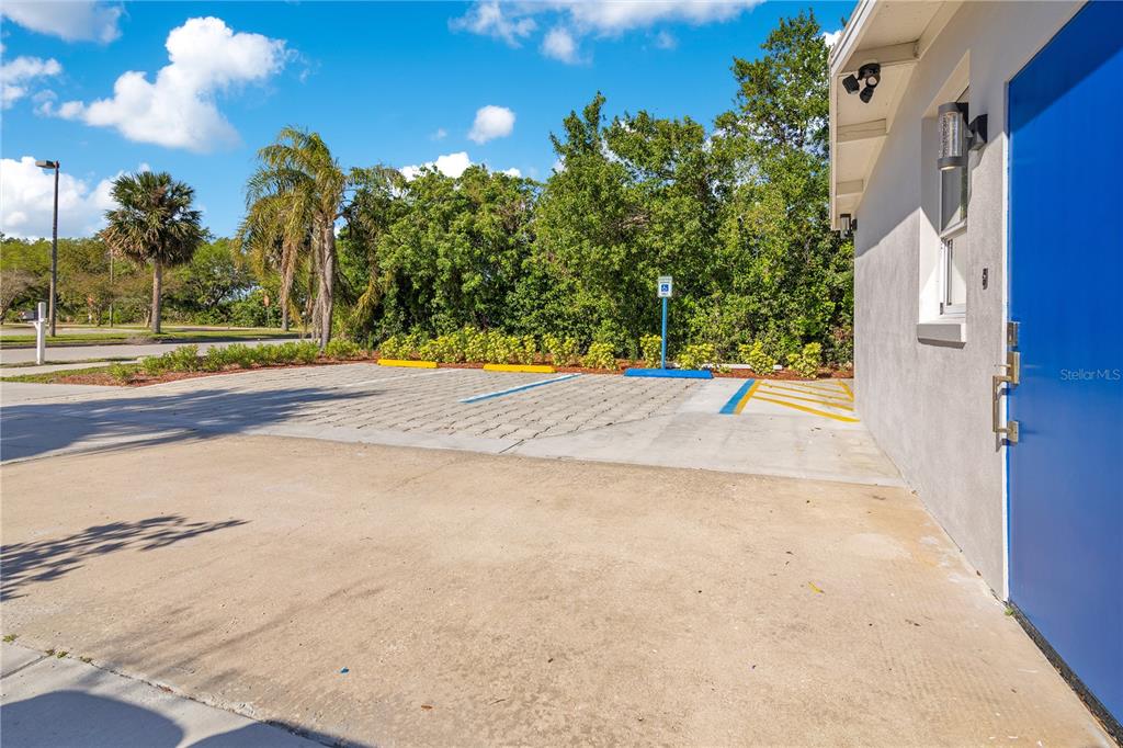 A paved parking area with a handicap space sits beside a building with a blue door — 4749 HARGRAVE STREET, ORLANDO, FL