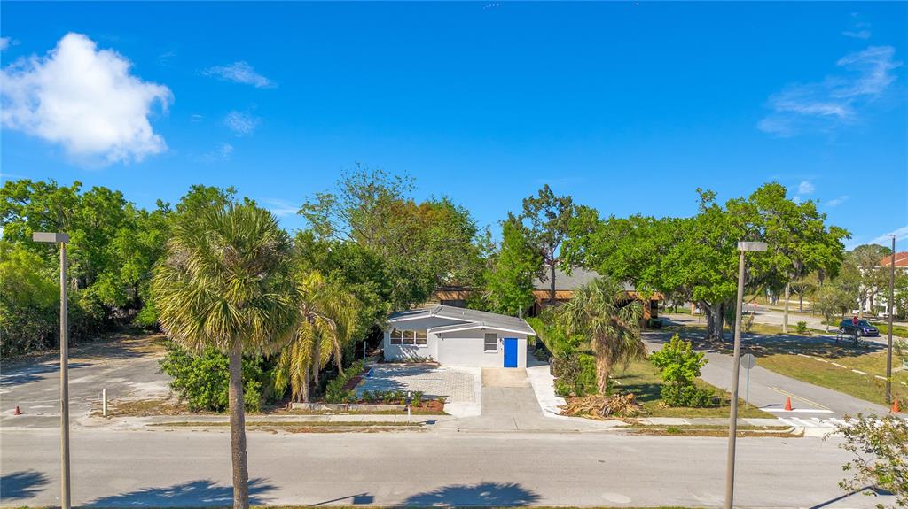 A single-story house with a blue door and a paved driveway sits among trees — 4749 HARGRAVE STREET, ORLANDO, FL