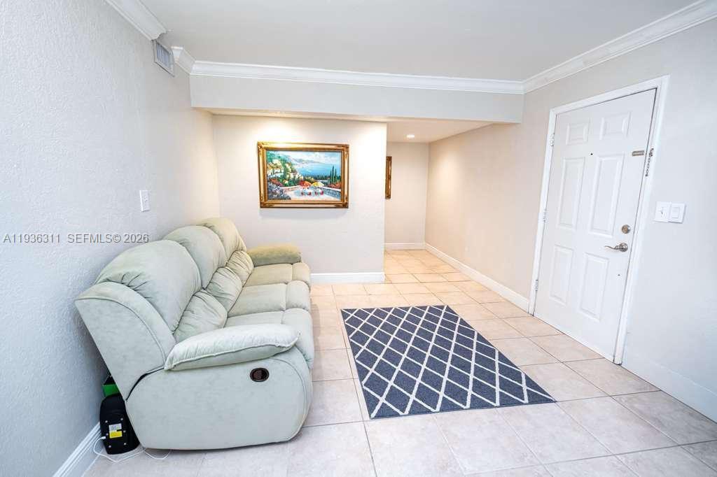 A light-colored sofa sits on a tiled floor next to a white door — 8600 SW 109th Ave # 114, Miami FL 33173, MIAMI, FL